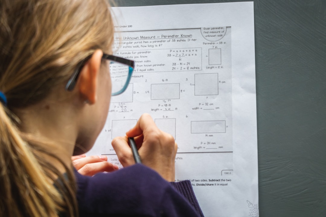Student with glasses working through a school assignment at home
